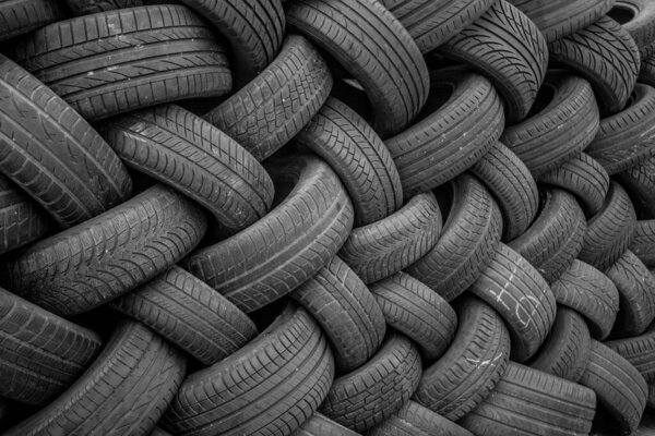 Фон, текстура стенки шин уложена под углом. Черная резина, автомобильная часть, запасная часть.