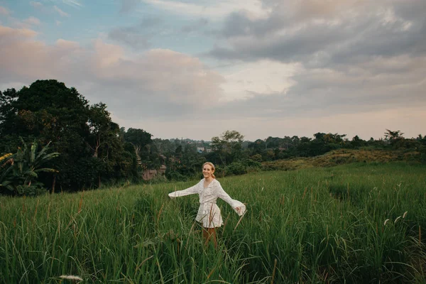 Wanita Muda Dengan Gaun Putih Terbang Berjalan Melalui Lapangan Rumput — Stok Foto