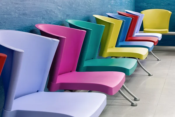 Cadeiras coloridas em uma sala de espera Fotos De Bancos De Imagens