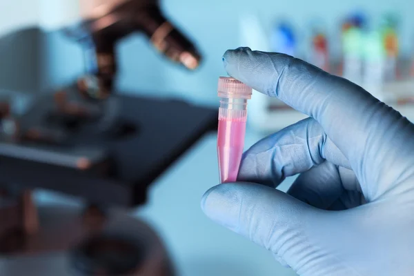 La mano de un médico sosteniendo un tubo — Foto de Stock