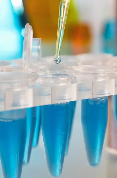 Detalle de una pipeta de laboratorio depositando una gota —  Fotos de Stock