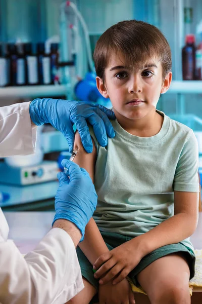 小児科医は小児病院の少年への注射で予防接種を行う 小児科で予防接種を受ける子どもたち — ストック写真