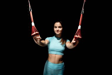 İbnelik eğitimi, yeni bir spor. Spor elbiseli genç bir kadın spor salonunda Alfagravity fitness kayışlarıyla bacak çalıştırıyor. Yüksek kalite fotoğraf