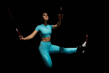 İbnelik eğitimi, yeni bir spor. Spor elbiseli genç bir kadın spor salonunda Alfagravity fitness kayışlarıyla bacak çalıştırıyor. Yüksek kalite fotoğraf