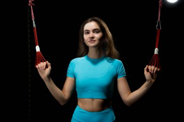 İbnelik eğitimi, yeni bir spor. Spor elbiseli genç bir kadın spor salonunda Alfagravity fitness kayışlarıyla bacak çalıştırıyor. Yüksek kalite fotoğraf