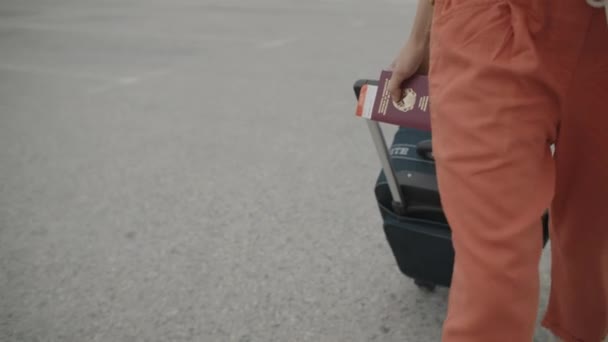 Kvinna med resväska går på en parkeringsplats — Stockvideo
