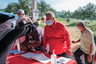 Muadzam Şah, Malezya - 6 Ekim 2021: Asyalı bir adam Durian 'da kızılötesi termometreyle ve Muadzam Şah' ta ananas bahçelerinde ateşini ölçüyor
