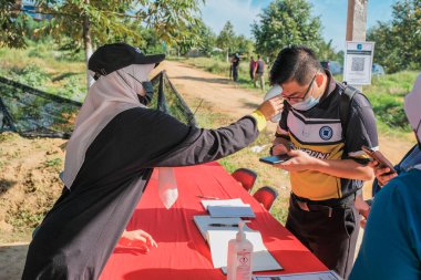 Muadzam Şah, Malezya - 6 Ekim 2021: Durian 'da kızıl ötesi termometre ve Muadzam Şah' taki ananas bahçelerinde Asyalı kadınların ateşi ölçülüyor