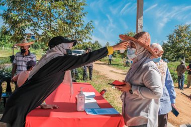 Muadzam Şah, Malezya - 6 Ekim 2021: Durian 'da kızıl ötesi termometre ve Muadzam Şah' taki ananas bahçelerinde Asyalı kadınların ateşi ölçülüyor