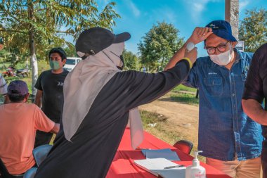 Muadzam Şah, Malezya - 6 Ekim 2021: Asyalı bir adam Durian 'da kızılötesi termometreyle ve Muadzam Şah' ta ananas bahçelerinde ateşini ölçüyor