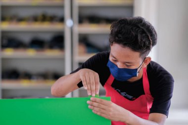 Genç marangozlar atölyeye yerleştirilen dolaplar için yapıştırıcı kullanırlar..