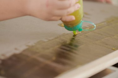 Genç marangozlar atölyeye yerleştirilen dolaplar için yapıştırıcı kullanırlar..