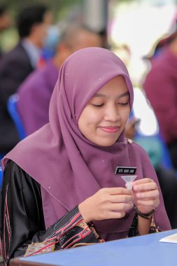 Muadzam Şah, Malezya - 25 Ocak 2022: Öğretmen salonda tükürük örneğiyle Covid-19 hızlı testi yaptı.