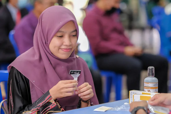 Muadzam Şah, Malezya - 25 Ocak 2022: Öğretmen salonda tükürük örneğiyle Covid-19 hızlı testi yaptı.