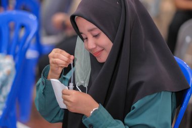 Muadzam Şah, Malezya - 25 Ocak 2022: Öğretmen salonda tükürük örneğiyle Covid-19 hızlı testi yaptı.
