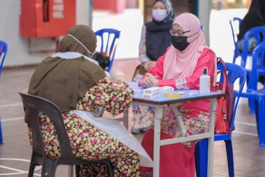 Muadzam Şah, Malezya - 25 Ocak 2022: Öğretmen salonda tükürük örneğiyle Covid-19 hızlı testi yaptı.