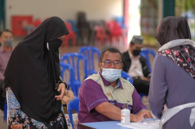 Muadzam Şah, Malezya - 25 Ocak 2022: Öğretmen salonda tükürük örneğiyle Covid-19 hızlı testi yaptı.