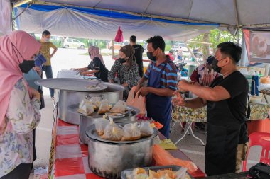 Segamat, Malaysia- April 2nd, 2022 : Muslim male vendors cooking and  selling halal foods from roadside stall  in holy month of Ramadan at Kuantan.