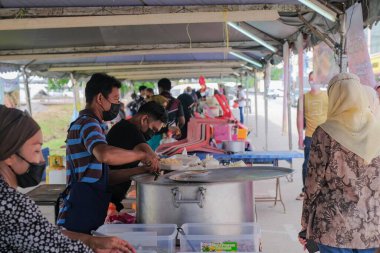 Segamat, Malezya - 2 Nisan 2022: Müslüman erkek satıcılar Kuantan 'daki kutsal Ramazan ayında yol kenarındaki tezgahlardan helal yiyecekler pişirip satıyorlar.