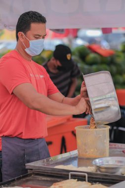 Segamat, Malaysia- April 2nd, 2022 : Muslim male vendors cooking and  selling halal foods from roadside stall  in holy month of Ramadan at Kuantan.