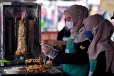 Segamat, Malaysia- April 2nd, 2022 : Muslim female vendors cooking and  selling halal foods from roadside stall  in holy month of Ramadan at Kuantan.