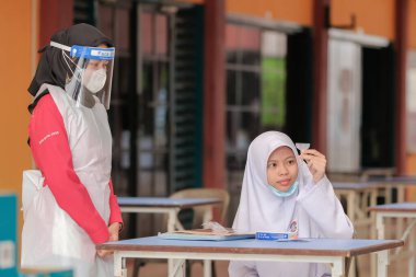 Muadzam Shah, Malaysia - April 7th, 2022 : Lateral-Flow-Test covid rapid home-use test kit for saliva - step 2 - spit with mouth through funnel in plastic tube to collect sample.