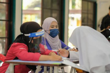 Muadzam Shah, Malaysia - April 7th, 2022 :  Happy muslim student with protective mask during  student enrolment day.