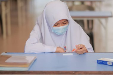 Muadzam Shah, Malaysia - April 7th, 2022 : New students made a quick Covid-19 test by placing saliva and fluid buffer observations during student enrolment day.