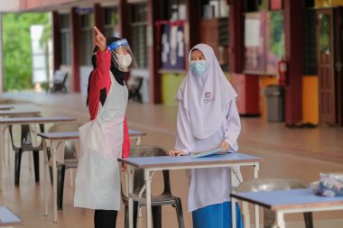 Muadzam Shah, Malaysia - April 7th, 2022 :  Happy muslim student with protective mask during  student enrolment day. clipart