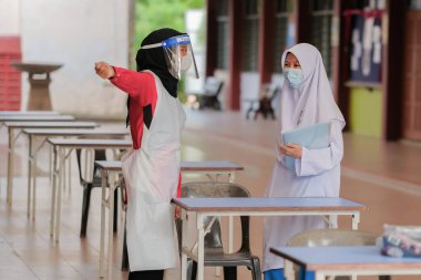 Muadzam Shah, Malaysia - April 7th, 2022 :  Happy muslim student with protective mask during  student enrolment day.
