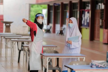 Muadzam Shah, Malaysia - April 7th, 2022 :  Happy muslim student with protective mask during  student enrolment day.