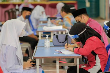 Muadzam Shah, Malaysia - April 7th, 2022 :  Happy muslim student with protective mask during  student enrolment day.