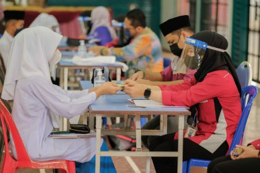 Muadzam Shah, Malaysia - April 7th, 2022 :  Happy muslim student with protective mask during  student enrolment day.