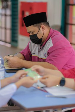 Muadzam Shah, Malaysia - April 7th, 2022 :  Happy muslim student with protective mask during  student enrolment day.