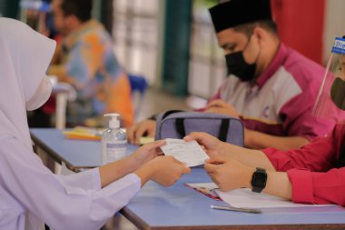 Muadzam Shah, Malaysia - April 7th, 2022 :  Happy muslim student with protective mask during  student enrolment day.