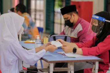 Muadzam Shah, Malaysia - April 7th, 2022 :  Happy muslim student with protective mask during  student enrolment day.