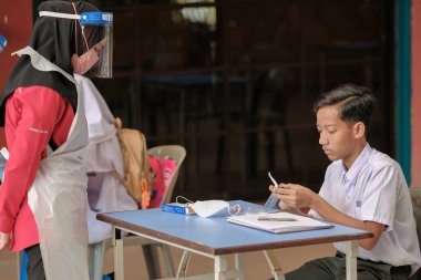 Muadzam Shah, Malaysia - April 7th, 2022 : New students made a quick Covid-19 test by placing saliva and fluid buffer observations during student enrolment day.