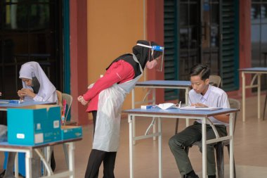 Muadzam Shah, Malaysia - April 7th, 2022 : New students made a quick Covid-19 test by placing saliva and fluid buffer observations during student enrolment day.
