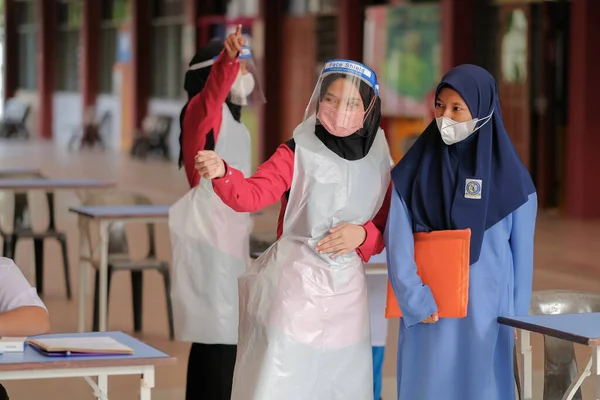 Muadzam Shah, Malaysia - April 7th, 2022 :  Happy muslim student with protective mask during  student enrolment day.