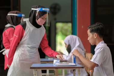 Muadzam Shah, Malaysia - April 7th, 2022 : New students made a quick Covid-19 test by placing saliva and fluid buffer observations during student enrolment day.