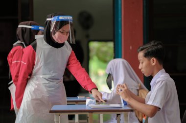 Muadzam Shah, Malaysia - April 7th, 2022 : New students made a quick Covid-19 test by placing saliva and fluid buffer observations during student enrolment day.