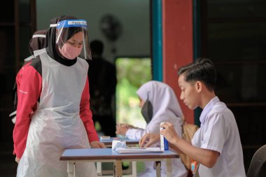 Muadzam Shah, Malaysia - April 7th, 2022 : New students made a quick Covid-19 test by placing saliva and fluid buffer observations during student enrolment day.