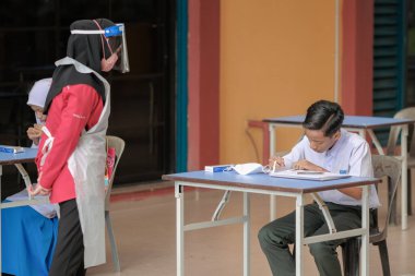 Muadzam Shah, Malaysia - April 7th, 2022 : New students made a quick Covid-19 test by placing saliva and fluid buffer observations during student enrolment day.