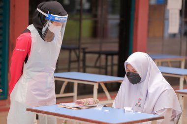 Muadzam Shah, Malaysia - April 7th, 2022 : New students made a quick Covid-19 test by placing saliva and fluid buffer observations during student enrolment day.