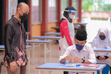 Muadzam Shah, Malaysia - April 7th, 2022 : New students made a quick Covid-19 test by placing saliva and fluid buffer observations during student enrolment day.