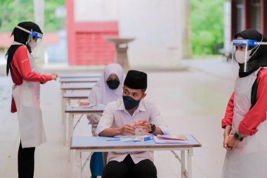 Muadzam Shah, Malaysia - April 7th, 2022 : New students made a quick Covid-19 test by placing saliva and fluid buffer observations during student enrolment day.