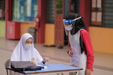 Muadzam Shah, Malaysia - April 7th, 2022 : New students made a quick Covid-19 test by placing saliva and fluid buffer observations during student enrolment day.