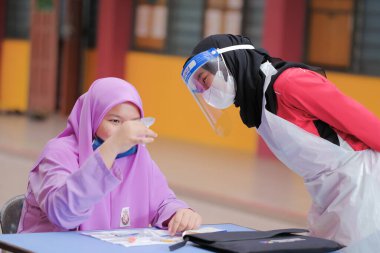 Muadzam Shah, Malaysia - April 7th, 2022 : Lateral-Flow-Test covid rapid home-use test kit for saliva - step 2 - spit with mouth through funnel in plastic tube to collect sample.