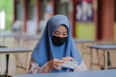 Muadzam Shah, Malaysia - April 7th, 2022 : New students made a quick Covid-19 test by placing saliva and fluid buffer observations during student enrolment day.