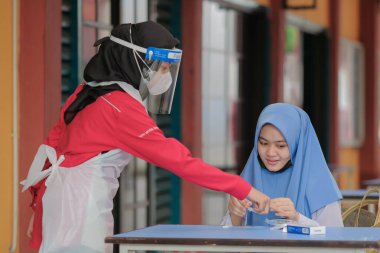 Muadzam Shah, Malaysia - April 7th, 2022 : New students made a quick Covid-19 test by placing saliva and fluid buffer observations during student enrolment day.